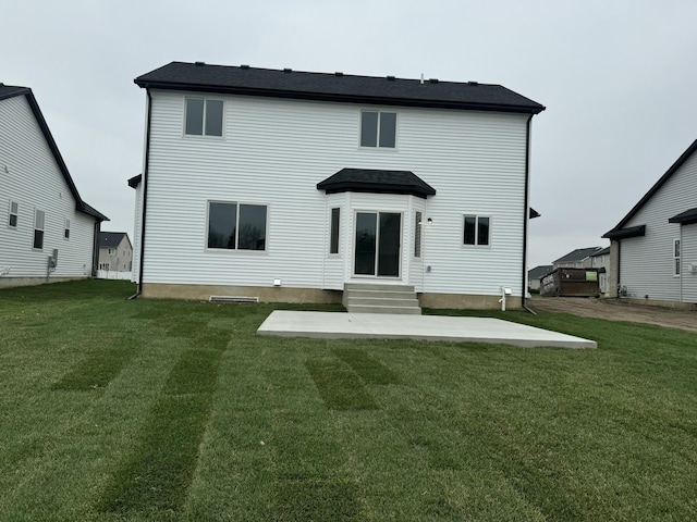 rear view of property featuring a lawn and a patio