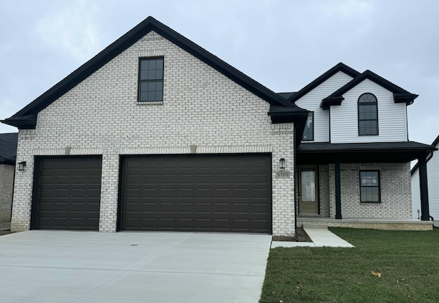 view of front of property featuring a porch, a garage, and a front yard