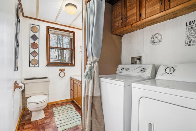 laundry room with dark parquet flooring, separate washer and dryer, and crown molding