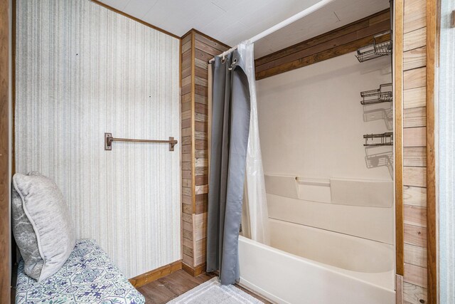 bathroom with hardwood / wood-style flooring and shower / tub combo with curtain