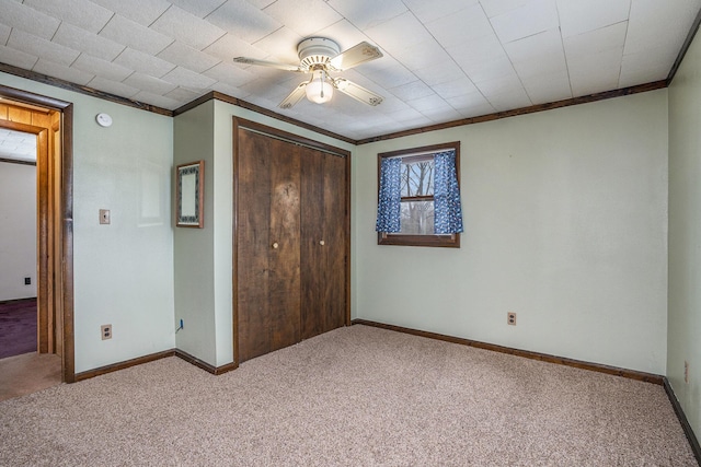 unfurnished bedroom with ceiling fan, ornamental molding, and carpet floors