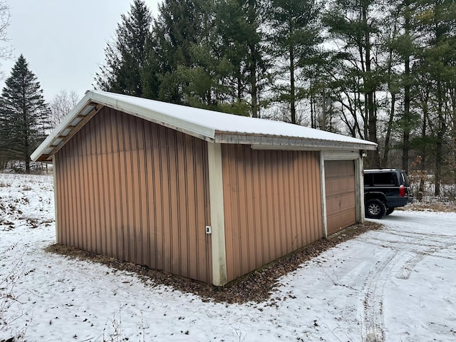 snow covered structure featuring a garage