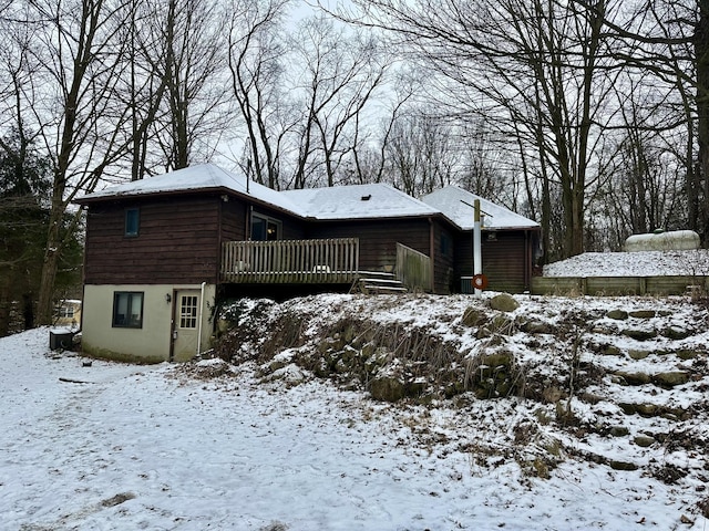 snow covered house featuring a deck