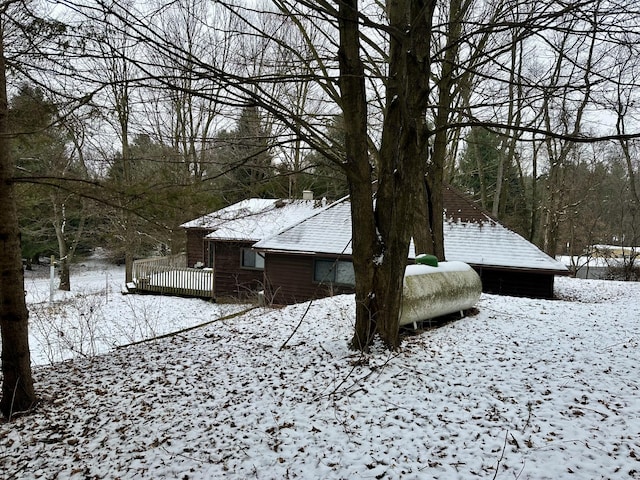 snow covered property with a wooden deck