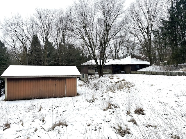 snowy yard with an outbuilding