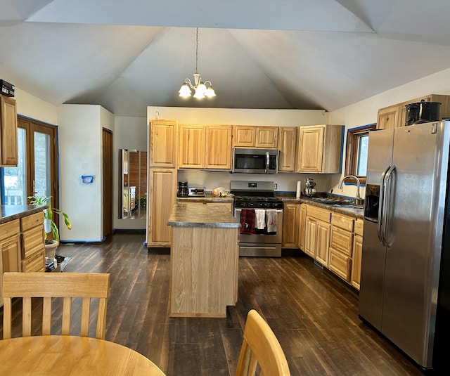 kitchen featuring appliances with stainless steel finishes, sink, pendant lighting, a notable chandelier, and a kitchen island