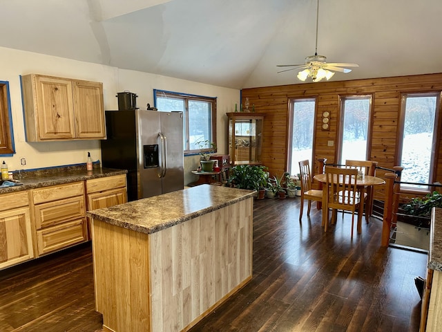 kitchen with light brown cabinets, vaulted ceiling, dark hardwood / wood-style floors, stainless steel fridge, and a kitchen island