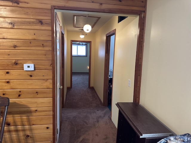 hall with dark colored carpet