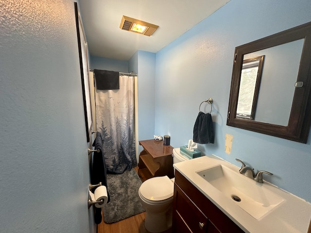 bathroom with curtained shower, vanity, wood-type flooring, and toilet