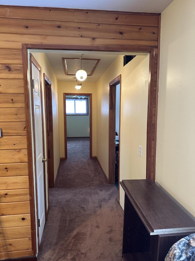 corridor featuring dark colored carpet