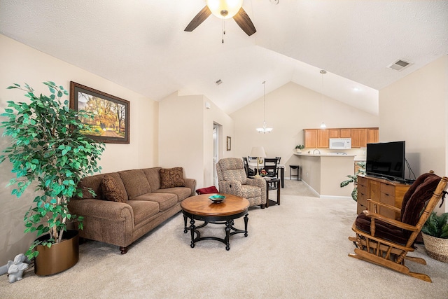 carpeted living room with ceiling fan with notable chandelier, lofted ceiling, and a textured ceiling