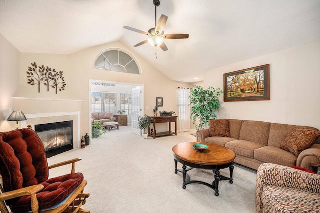 living room featuring ceiling fan, carpet floors, plenty of natural light, and a tiled fireplace