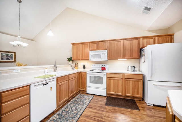 kitchen featuring pendant lighting, white appliances, an inviting chandelier, sink, and wood-type flooring