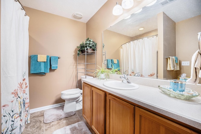 bathroom with a textured ceiling, vanity, and toilet