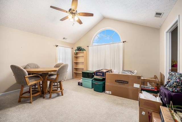 interior space featuring a textured ceiling, ceiling fan, carpet floors, and lofted ceiling