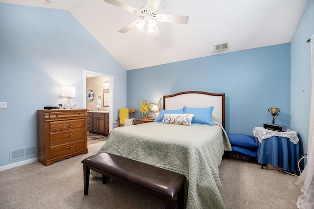 bedroom featuring ceiling fan, light colored carpet, connected bathroom, and vaulted ceiling