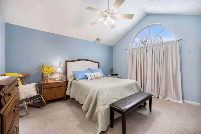 carpeted bedroom with a textured ceiling, ceiling fan, and vaulted ceiling