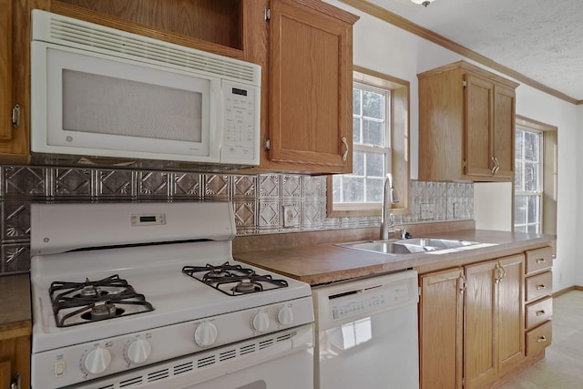 kitchen featuring crown molding, white appliances, sink, and tasteful backsplash