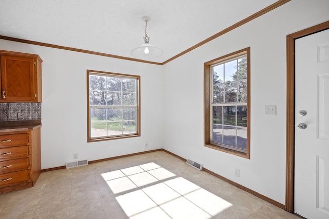 unfurnished dining area featuring light tile patterned floors and ornamental molding