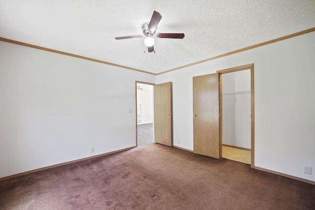 unfurnished bedroom featuring carpet flooring, ceiling fan, a textured ceiling, a closet, and ornamental molding