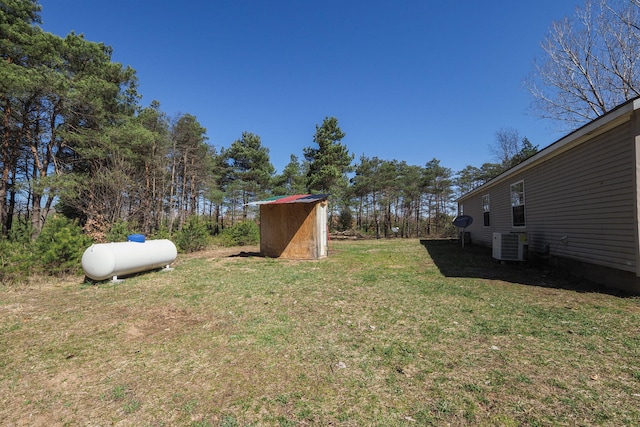 view of yard featuring central AC unit and a storage shed