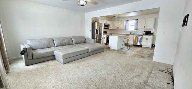 carpeted living room with ceiling fan