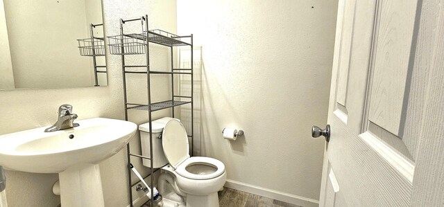 bathroom featuring hardwood / wood-style flooring and toilet