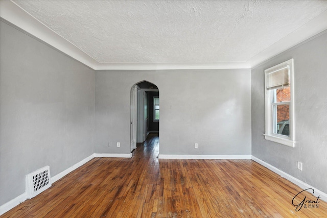 unfurnished room featuring a textured ceiling and dark hardwood / wood-style floors