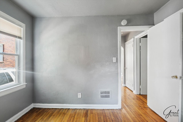 unfurnished room with hardwood / wood-style floors