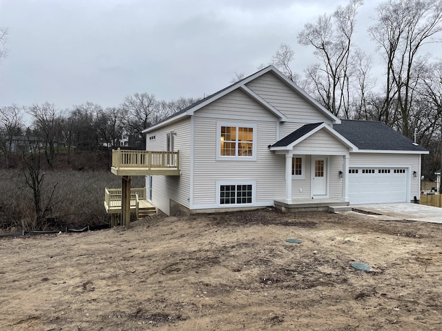 view of front of home with a garage, concrete driveway, and a wooden deck