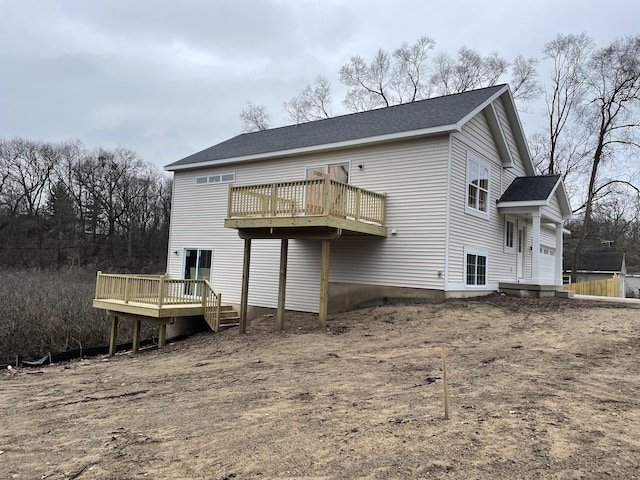 back of property with a deck and roof with shingles