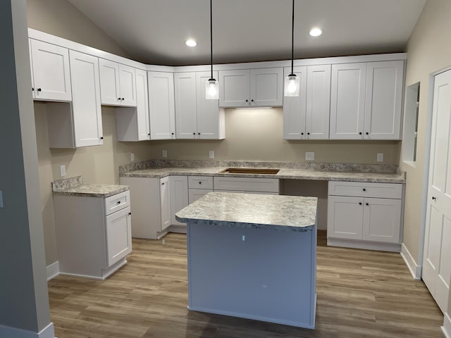 kitchen with light wood-style flooring, a kitchen island, white cabinetry, and recessed lighting