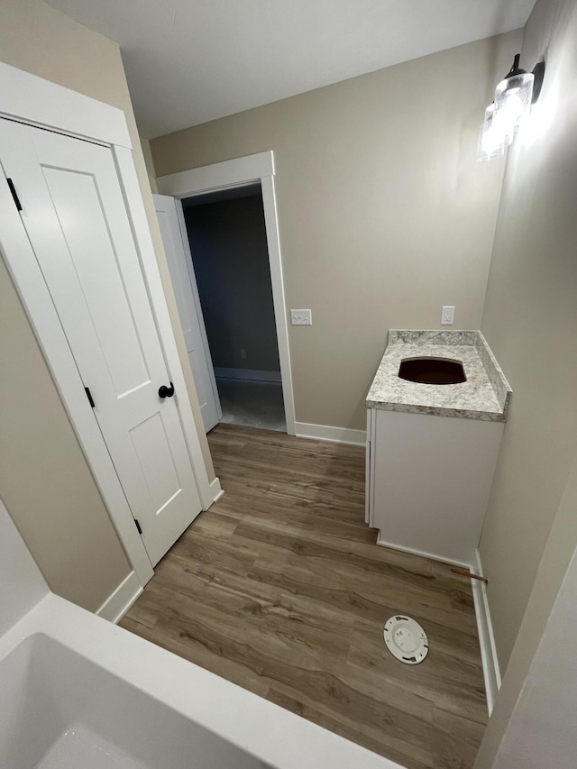 bathroom with wood finished floors, vanity, and baseboards