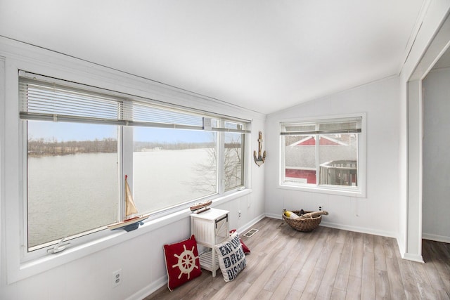 sunroom with a water view and vaulted ceiling