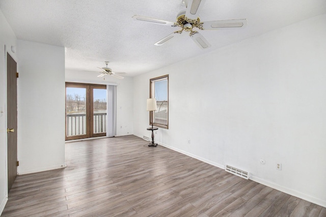 spare room featuring hardwood / wood-style floors, ceiling fan, and a textured ceiling