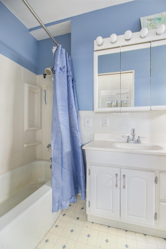 bathroom featuring vanity, backsplash, and shower / bathtub combination with curtain