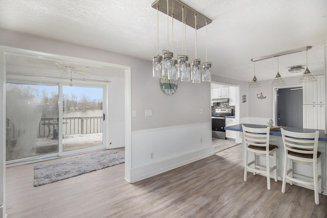 dining space with light hardwood / wood-style flooring and a textured ceiling