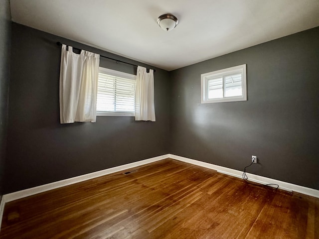 empty room featuring wood-type flooring and a healthy amount of sunlight