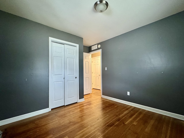 unfurnished bedroom with hardwood / wood-style flooring and a closet