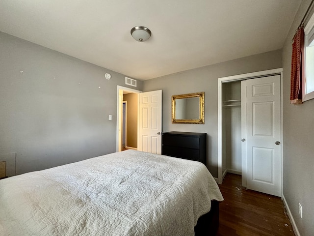 bedroom with dark hardwood / wood-style floors and a closet