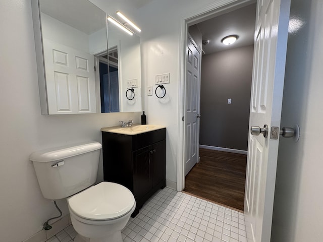 bathroom featuring tile patterned flooring, vanity, and toilet