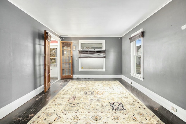 spare room featuring dark hardwood / wood-style flooring, a wealth of natural light, and ornamental molding