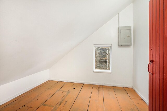 bonus room with light hardwood / wood-style floors and electric panel