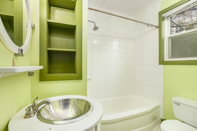 full bathroom with tiled shower / bath combo, toilet, and sink