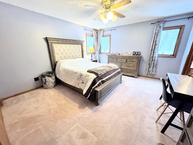 carpeted bedroom with ceiling fan and a textured ceiling