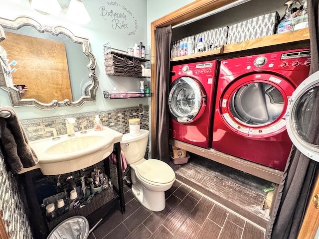 bathroom with washing machine and clothes dryer, decorative backsplash, sink, and toilet