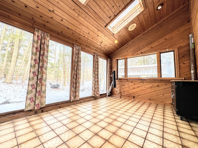 unfurnished sunroom featuring vaulted ceiling with skylight, a healthy amount of sunlight, and wood ceiling