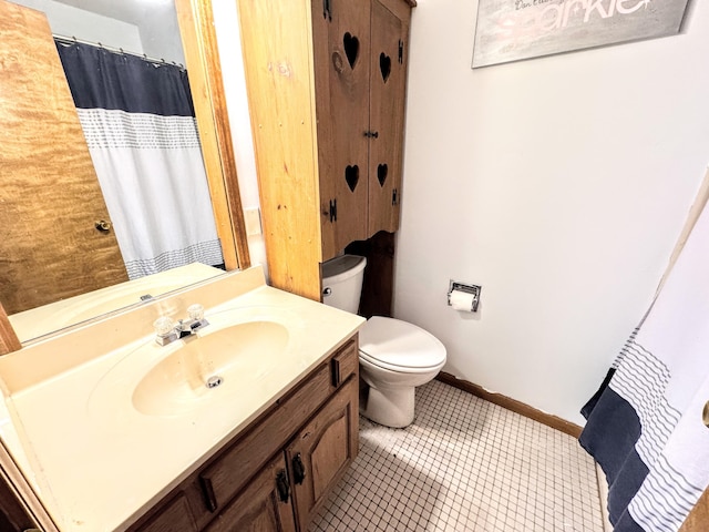 bathroom with tile patterned flooring, vanity, and toilet