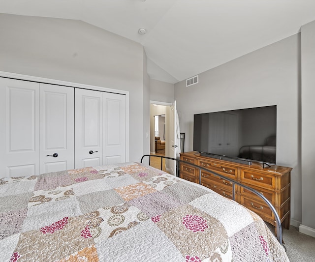 carpeted bedroom with lofted ceiling and a closet