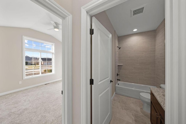 full bathroom featuring toilet, tiled shower / bath, vaulted ceiling, vanity, and ceiling fan